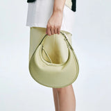 Woman holding a light yellow crescent handbag, fashion accessory from Amazing Song