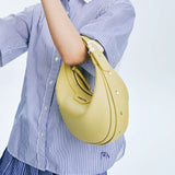 Woman in striped shirt holding yellow leather Amazing Song handbag