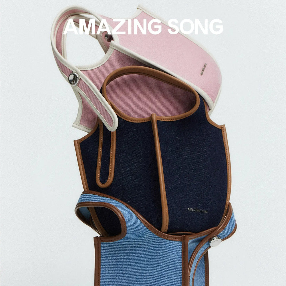 Amazing Song denim and pink canvas bags with brown trim, stacked on white background