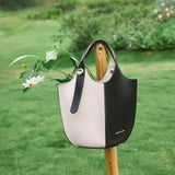 Black and white leather tote bag with flowers, outdoor grass background, Amazing Song
