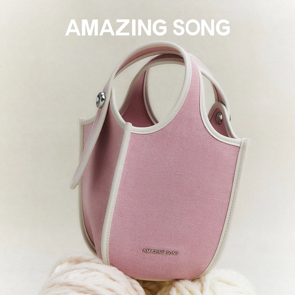 Amazing Song pink handbag with cream trim on a soft beige background