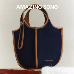 Amazing Song navy blue denim handbag with brown leather trim on neutral background