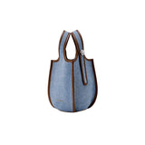 Light blue denim tote bag with brown leather trim, displayed on white background