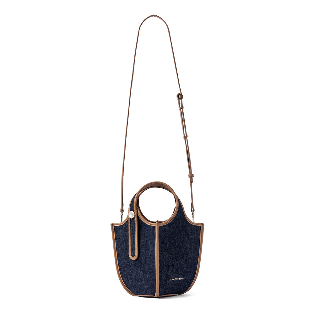 Amazing Song denim handbag with brown trim and adjustable shoulder strap on white background