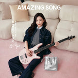 Woman with pink bass guitar and silver Amazing Song bag on beige sofa, official website promo
