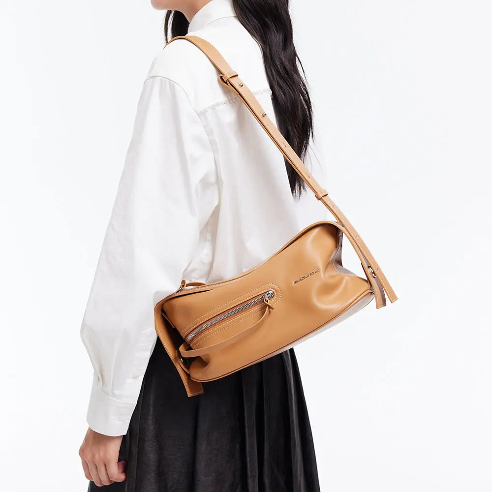 Woman wearing tan leather shoulder bag, white shirt, and black skirt on Amazing Song site