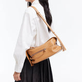 Woman wearing tan leather shoulder bag, white shirt, and black skirt on Amazing Song site