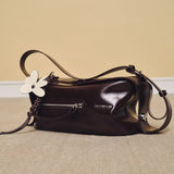 Amazing Song dark brown leather shoulder bag with flower charm on beige carpet