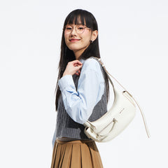 Woman wearing glasses and a white shoulder bag, posing stylishly for Amazing Song brand