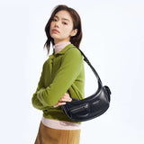 Woman in green sweater with black leather shoulder bag, Amazing Song fashion accessory