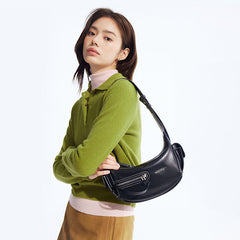 Woman in green sweater with black leather shoulder bag, Amazing Song fashion accessory