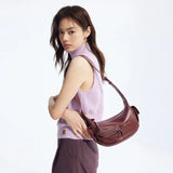 Woman in lilac sleeveless top with burgundy shoulder bag, Amazing Song fashion accessory