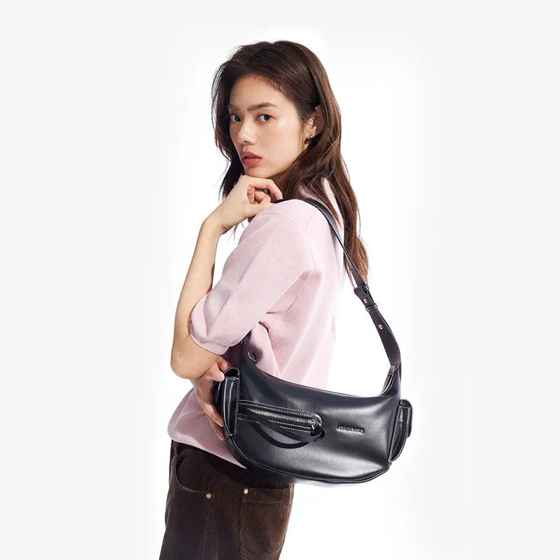 Woman modeling black shoulder bag, pink top, Amazing Song fashion accessory