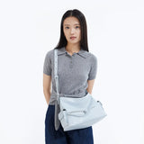 Woman in grey polo shirt modeling light blue crossbody bag, Amazing Song official website