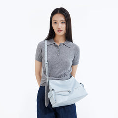 Woman in grey polo shirt modeling light blue crossbody bag, Amazing Song official website