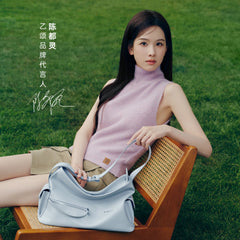 Woman in pink sleeveless top with light blue handbag on wooden chair, grass background, Amazing Song