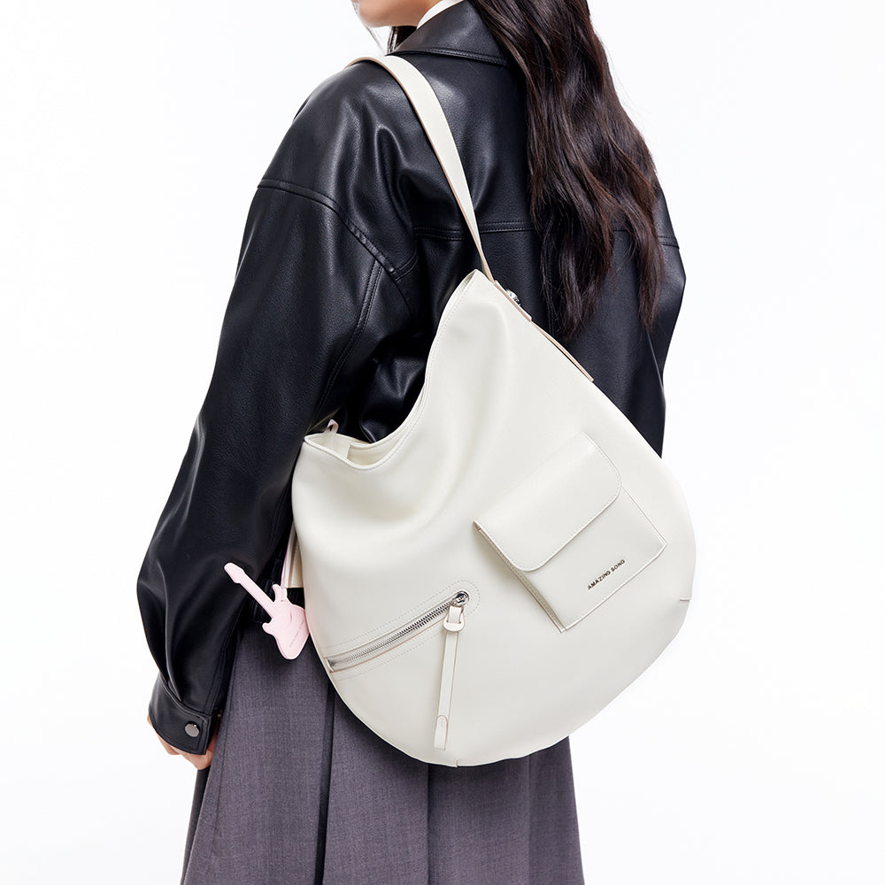 Woman wearing a black leather jacket with an Amazing Song white shoulder bag