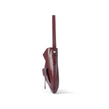 Side view of burgundy leather shoulder bag with front pocket on white background