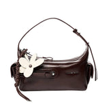 Amazing Song brown leather shoulder bag with white flower charm on white background