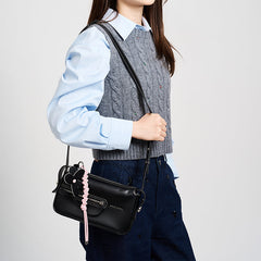Woman wearing blue shirt and grey knit vest with black shoulder bag, Amazing Song fashion