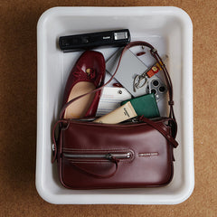 Burgundy Amazing Song handbag, matching flat shoe, camera, and essentials in white tray