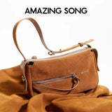 Amazing Song brown suede shoulder bag with zipper, displayed on matching fabric