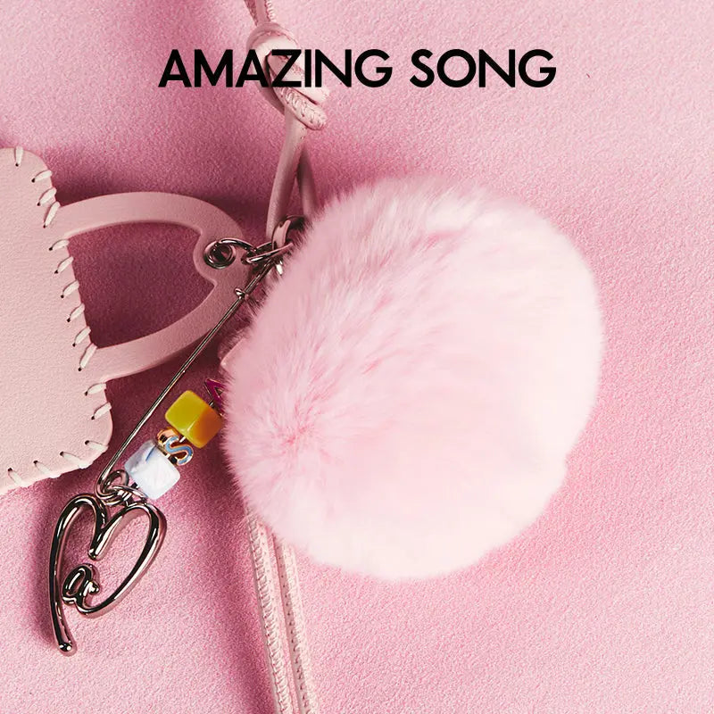 Pink fluffy pom pom keychain and handbag accessory on pink background, Amazing Song brand