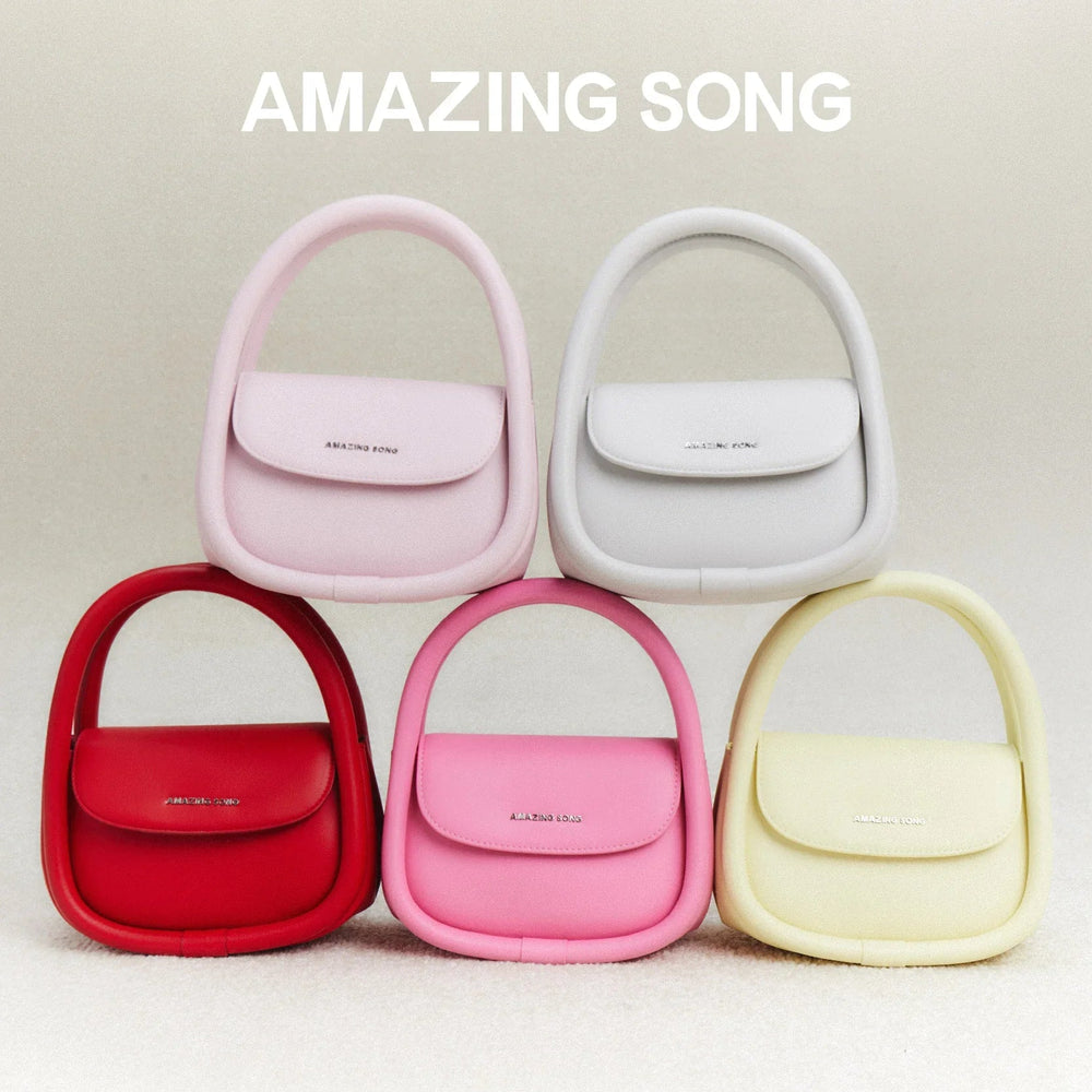 Amazing Song handbags in red, pink, white, and yellow displayed on soft beige background