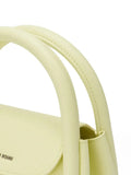 Close-up of pale yellow Amazing Song handbag with curved handles and logo detail