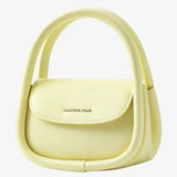 Pastel yellow Amazing Song handbag with curved handle on white background