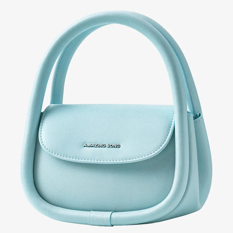 Light blue Amazing Song handbag with curved handles and logo on front, isolated on white