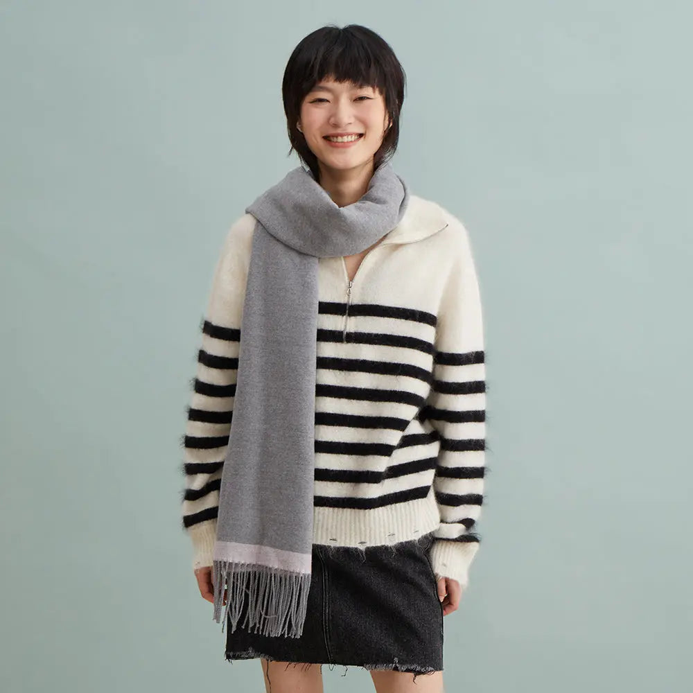 Smiling woman in striped sweater, gray scarf, and black skirt on Amazing Song website