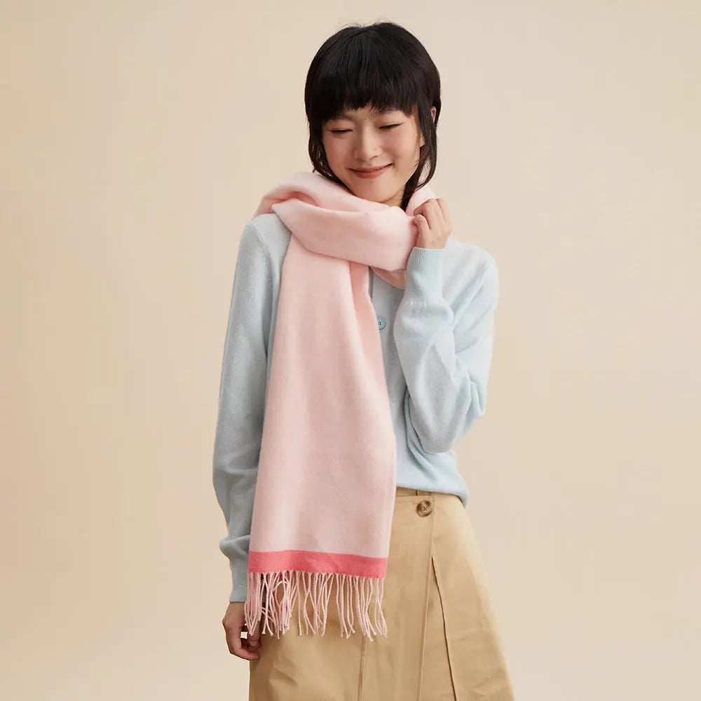 Smiling woman wearing a soft pink scarf and light blue sweater, Amazing Song official website