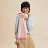 Smiling woman wearing a soft pink scarf and light blue sweater, Amazing Song official website