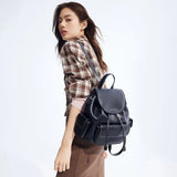Woman in plaid shirt modeling black Amazing Song backpack against white background