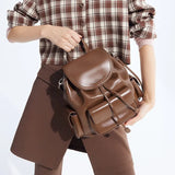 Woman holding brown leather backpack, plaid shirt and brown skirt, Amazing Song bag