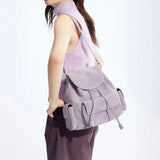 Woman in sleeveless lilac top modeling a light purple suede backpack, Amazing Song official site