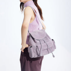 Woman in sleeveless lilac top modeling a light purple suede backpack, Amazing Song official site