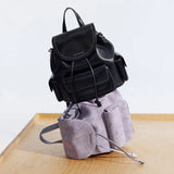 Amazing Song black leather and lavender suede backpacks stacked on wooden surface