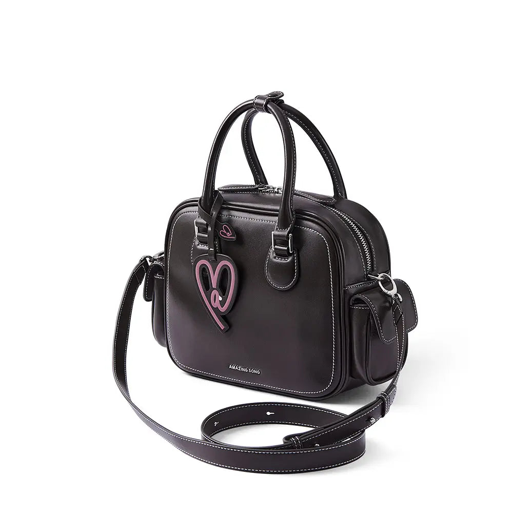 Black Amazing Song handbag with pink heart charm, double handles, and white stitching
