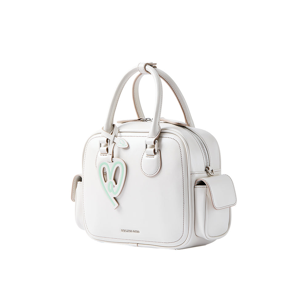 White Amazing Song handbag with mint heart charm, side pocket, and top handles