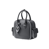 Amazing Song black handbag with heart keychain and white trim on white background