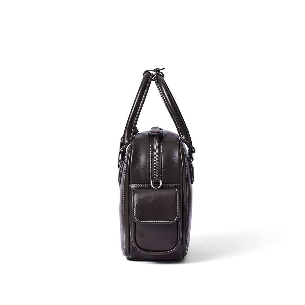 Side view of a dark brown leather handbag with white stitching and pocket, Amazing Song