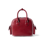 Red leather handbag with double top handles and side pockets on white background