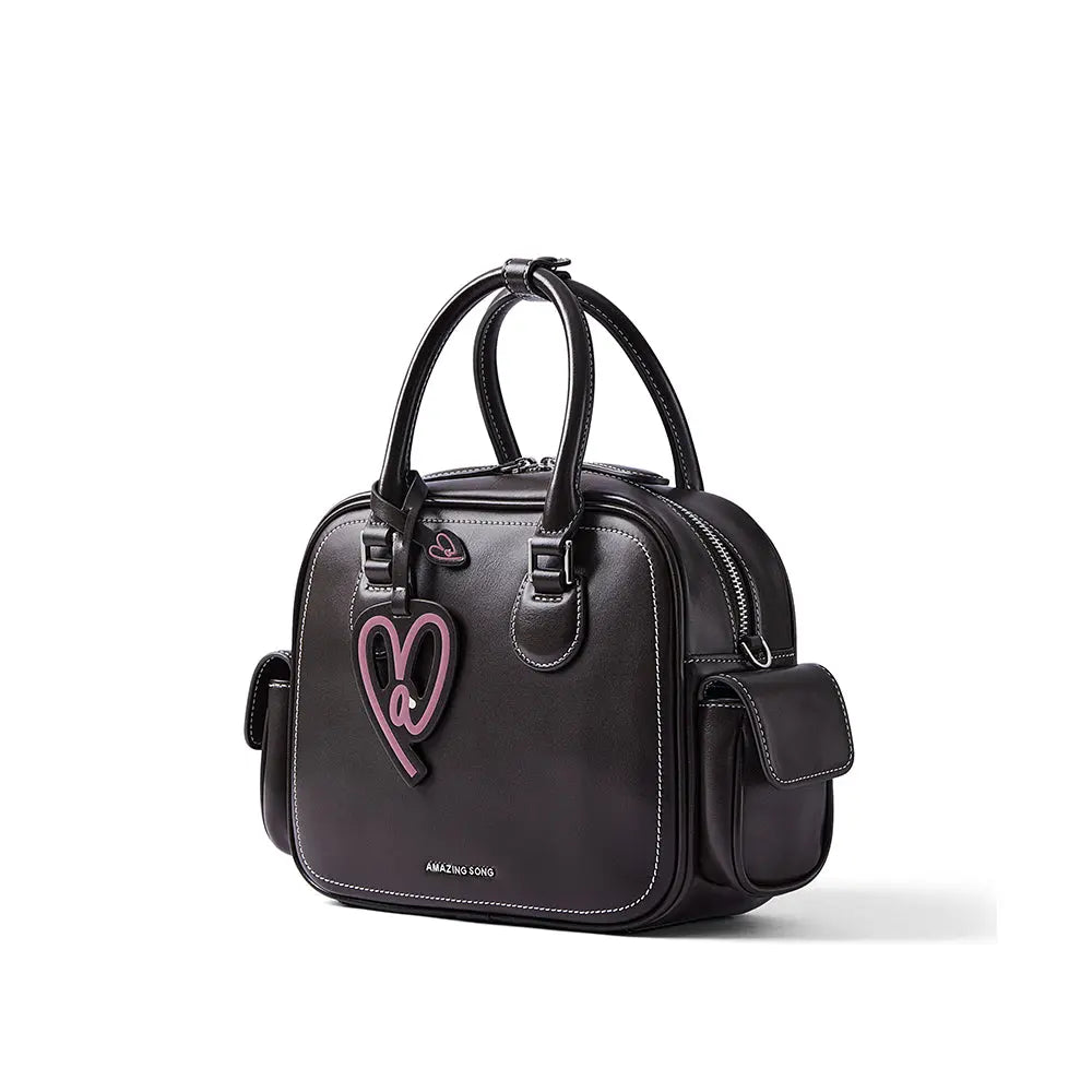 Amazing Song black leather handbag with pink heart charm and white stitching