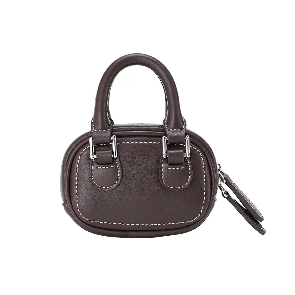 Dark brown mini handbag with white stitching, two handles, and silver hardware, on white background.