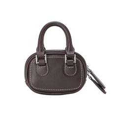 Dark brown mini handbag with white stitching, two handles, and silver hardware, on white background.