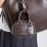 Amazing Song brown leather mini bag with white stitching attached to larger matching bag
