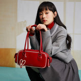 Woman with long hair holding a red Amazing Song handbag, stylish modern fashion