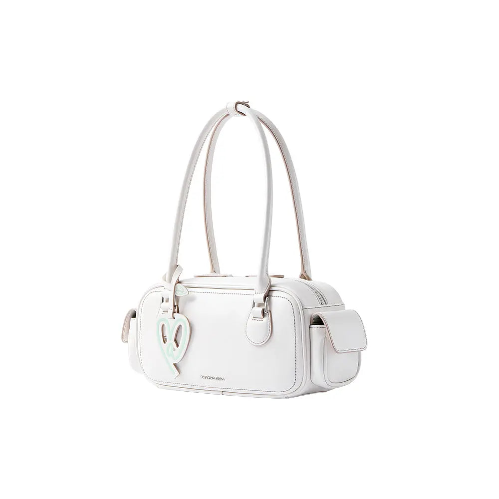 White Amazing Song handbag with heart charm and long straps, studio background.